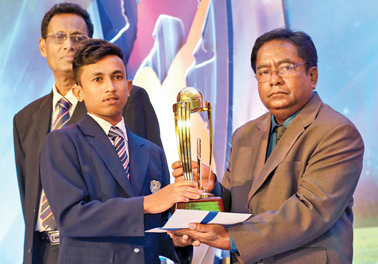 Senior Associate Editor Rodney Martinuz hands over the Trophy to Best Bowler Award Division III to Sasanga Dulaj of Henegama MMV