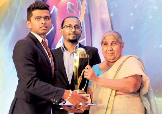 Best Batsman in Division II Raveen Yasas of Devapathiraja College receiving his Award from Chief Editor of Dinamina Pushpa Rowel