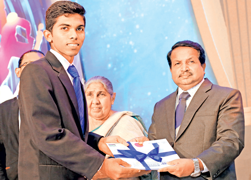 The Best Fielder Division II Sumith Isuru of Karandeniya Central College receiving his certificate from K. Kunarasa the Editor in Chief of Thinakaran and Varamanjari  