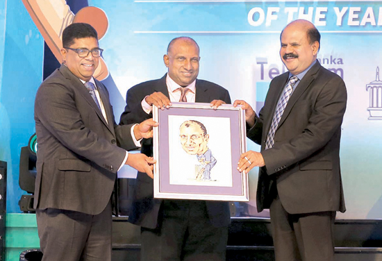 Krishantha Cooray (L) Chairman of ANCL and P.G. Kumarasinghe (Chairman Telecom and Mobitel (Pvt) Limited) presenting a portrait to Aravinda de Silva done by Sunday Observer cartoonist Wasantha Siriwardena