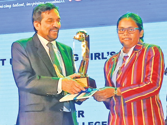 Captain of the best up-and-coming girls school Princess of Wales College receives the award from Media and Information Ministry Secretary Jagath P Wijeweera