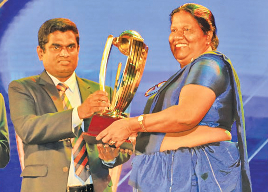 Division one - Best Fielder winner  Pawan Ratnayake of Mahanama College. His mother receives the Award on behalf of him from SLSCA Treasurer, Manjula Vaas